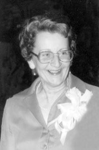 Black and white phot of Joan Willoughby, an older white woman with short gray hair who is smiling